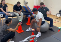 Instructor sitting on balance ball giving lecture