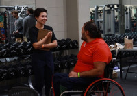 Fitness instructor and patient in wheelchair having a conversation