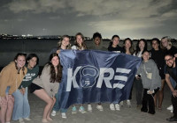 Students in the KORE organization taking photo on the beach