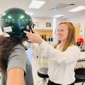 Michelle Rawlins putting helmet on student