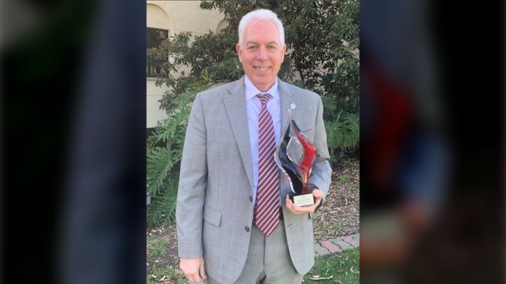 Dr. Steve Hooker holding his award