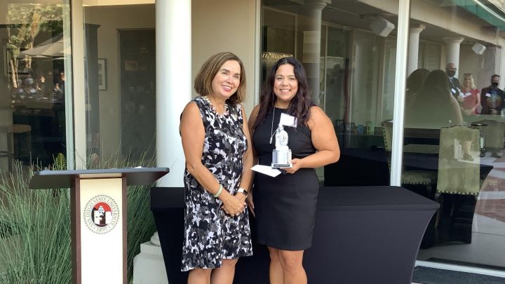 President Adella De La Torre with Cathy Chavez holding an award